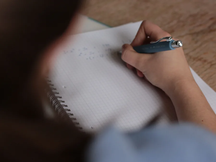 Alumno de Nivel Primario escribiendo en clase